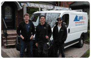 Three Laird & Son Heating & Air Conditioning technicians standing in front of a service van, ready to provide HVAC services in Toronto neighborhoods.