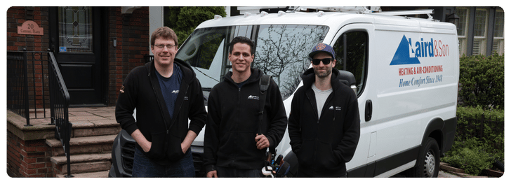 Three HVAC technicians in branded jackets standing in front of a Laird & Son service van, showcasing their expertise in heating and air conditioning solutions for homeowners in the Greater Toronto Area.